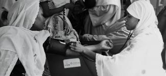 Doctor measuring woman's blood pressure